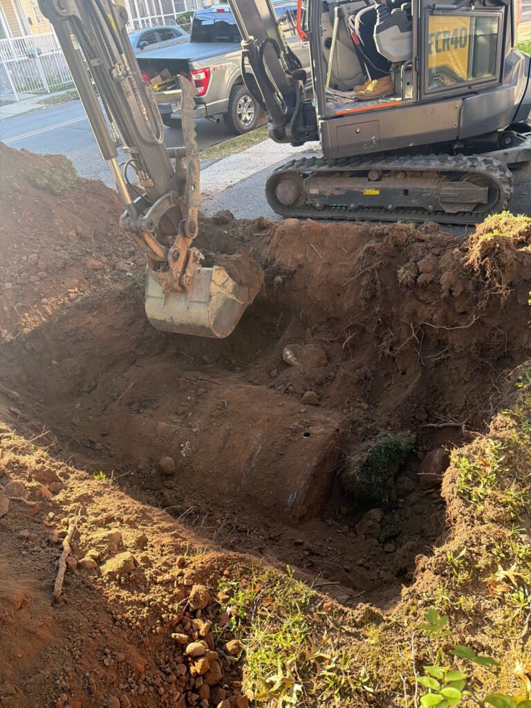 Mini excavator performing underground oil tank excavation in Newark, New Jersey.